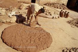 Image du Maroc Professionnelle de  Un ouvrier prend une parts d’argile pétrit, destinée au tourneur cette partie d’argile brut imprégnée d’eau se transformera en une forme d’objet grâce au savoir faire des artisans dans les ateliers de la Colline des Potiers à Safi, Vendredi 29 Août 1997. (Photo / Abdeljalil Bounhar) 